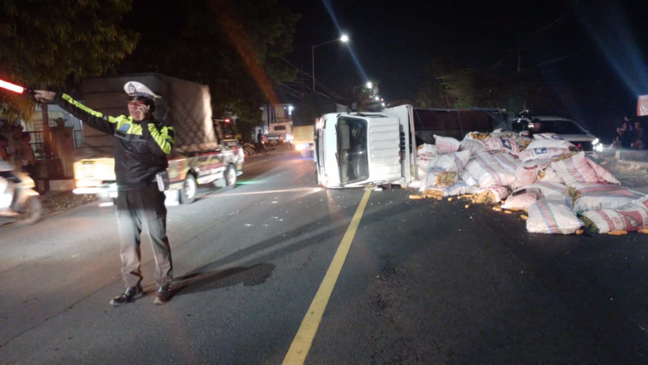 Caption : Truk engkel warna putih bermuatan jagung yang terguling di Jalan Raya Jurusan Jember, tepatnya di selatan Mapolsek Kabat, Banyuwangi, Selasa (14/11/2023) malam.(blok-a.com/Kuryanto)