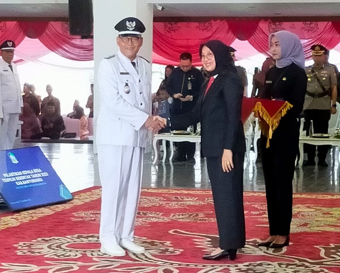 Bupati Banyuwangi, Ipuk Fiestiandani berjabat tangan dengan salah satu Kades terpilih, Pilkades serentak 25 Oktober 2023, Kades Genteng Kulon, Drs. Supandi M.Pd, saat pelantikan, Jumat (15/12/2023).(blok-a.com/Kuryanto)