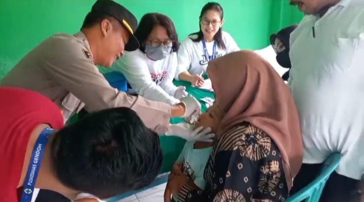 Caption : Kapolsek Sempu, AKP Karyadi SH, saat memberikan vaksin Polio pada balita di Pukesmas Gendoh, Kecamatan Sempu, Sabtu (20/1/2024)(blok-a.com/Kuryanto).