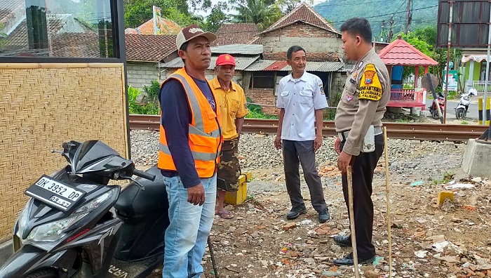 Petugas Kapolsek Kalibaru, saat sambangi relawan petugas jaga palang pintu KA di perlintasan sebidang, Kamis (25/1/2024).(blok-a.com/Kuryanto)