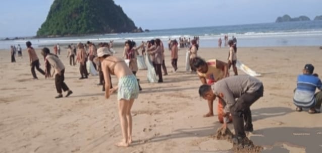 Saka Bhayangkara Pangkalan Harimau Jawa Polsek Pesanggaran, Banyuwangi, beserta pengelola wisata, Pokmas, warga sekitar, juga wisatawan membersihkan sampah kiriman di Pantai Pulau Merah, Kamis (18/1/2024).(dok. Polsek Pesanggaran untuk blok-a.com)