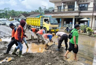 Pembersihan luapan air bercampur meterial tanah di badan Jalan Raya perempatan Bu Bejo, Desa Kalibaru Manis, Kecamatan Kalibaru, Jumat (19/4/2024).(blok-a.com/Kuryanto)