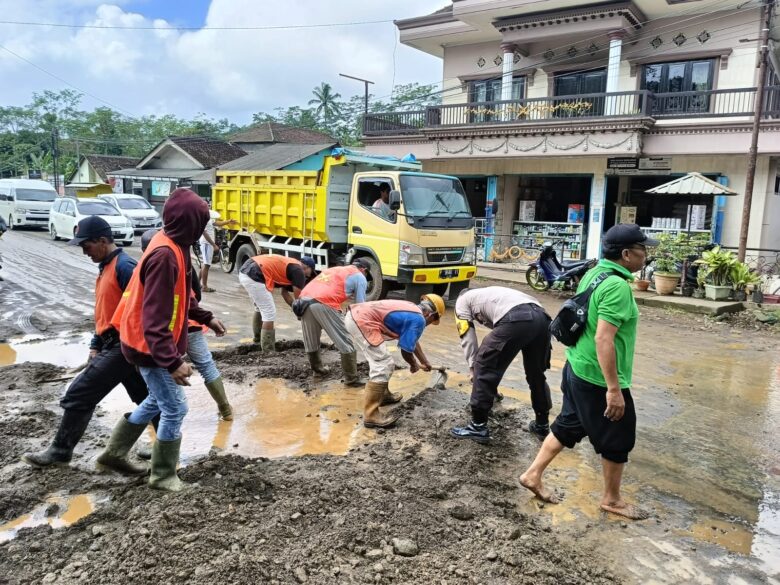 Pembersihan luapan air bercampur meterial tanah di badan Jalan Raya perempatan Bu Bejo, Desa Kalibaru Manis, Kecamatan Kalibaru, Jumat (19/4/2024).(blok-a.com/Kuryanto)