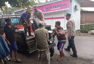 Plt Kapolsek Genteng, AKP Nanang Wardhana dibantu warga sekitar saat mengevakuasi motor korban laka beruntun, Rabu (24/4/2024).(blok-a.com/Kuryanto)