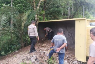 Anggota Polsek Licin membantu bersihkan tanah dan mengatur lalulintas pada insiden truk terguling di Jalan tanjakan Kecamatan Licin, Selasa (2/7/2024).(blok-a.com/Kuryanto)