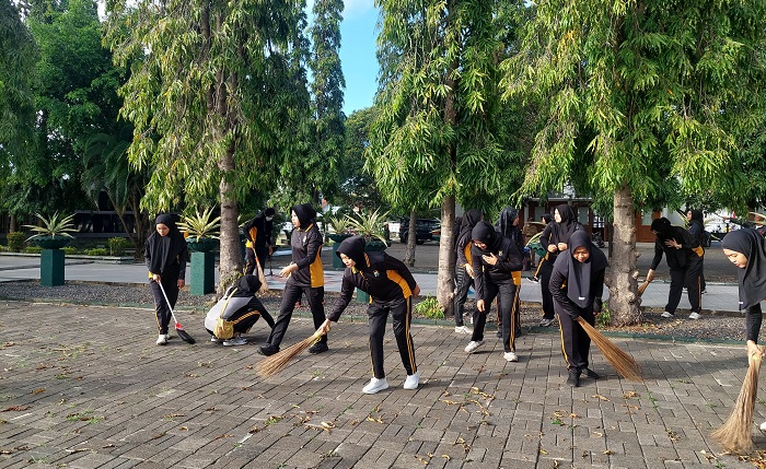 Polwan Polresta Banyuwangi saat lakukan kegiatan sosial kerja bhakti di TMP Wisma Raga Satria Banyuwangi, Selasa (20/8/2024).(blok-a.com/Kuryanto)