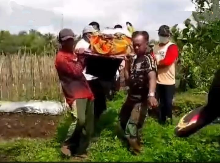 Caption : Polisi dibantu warga saat mengevakuasi mayat pria yang ditemukan meninggal di sebuah parit di area persawahan di Kecamatan Genteng, Minggu (1/8/2024)(blok-a.com/Kuryanto).
