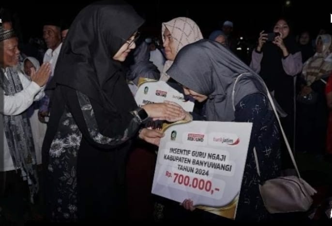 Caption : Bupati Ipuk, secara simbolis saat meberikan gaji insentif guru ngaji pada gelar memperingati Maulid Nabi SAW di Pantai Marina Boom Banyuwangi, Sabtu (14/9/2024)(blok-a.com/Istimewa).