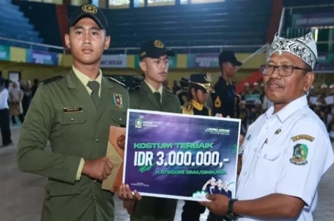 Plt Bupati Banyuwangi Sugirah saat memberikan penghargaan kepada salah satu pemenang Kostum Terbaik kategori SMA/SMK kompetisi LKBB Banyuwangi 2024, Rabu (25/9/2024).(blok-a.com/Kuryanto)