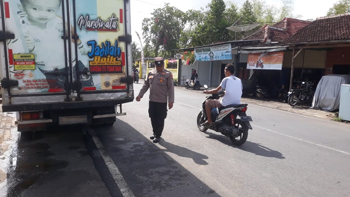 Petugas Polsek Pesanggaran melakukan olah TKP kecelakaan antara motor dan truk box yang parkir di bahu jalan. (blok-a.com/Kuryanto)