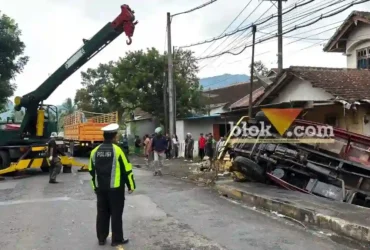 Pilket Lantas Polsek Kalibaru, saat mengevakuasi truk bermuatan buah naga yang mengalami laka tunggal di Jalan Raya Banyuwangi-Jember, Rabu (14/1/2026) sore. (Blok-a.com/Kuryanto).