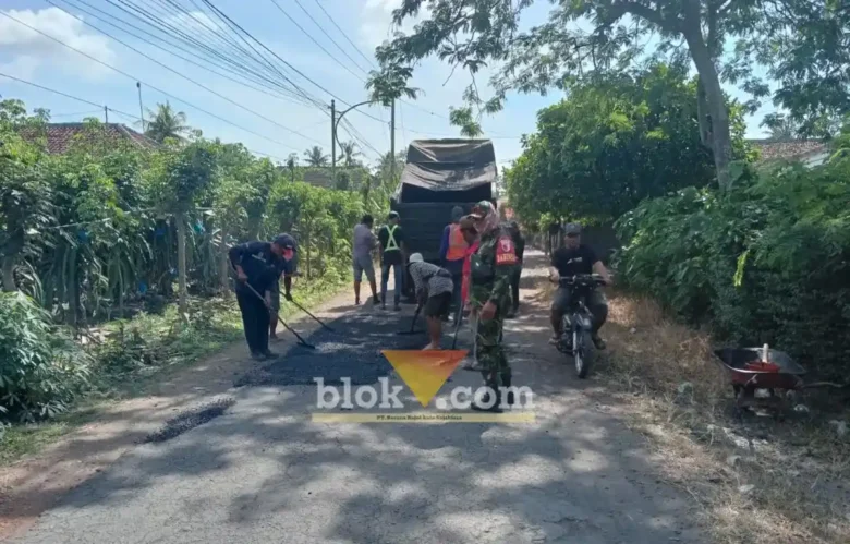 Babinsa Koramil 0825/09 Tegaldlimo saat memonitor dan membantu warga memperbaiki jalan Desa Kedunggebang, Kecamatan Tegaldlimo, Senin (13/07/2026)(foto: Blok-a.com/Kuryanto)
