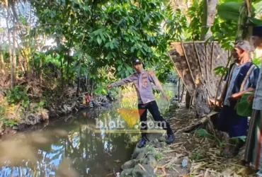 Kanit Intelkam Polsek Singojuruh, Aiptu Firdaus saat menunjukkan lokasi ditemukan Muawanah, lansia yang meninggal dunia di sungai belakang rumahnya, Senin (06/07/2026)(foto: Blok-a.com/Kuryanto)