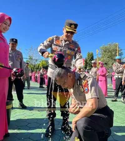 Kapolresta Banyuwangi, Kombes Pol. Dr. Rofiq Ripto Himawan, bersama Ketua Bhayangkari Cabang Banyuwangi, Ny Sari Rofiq, saat menyiram air bunga pada salah satu anggota pada momen Upacara Laporan Kenaikan Pangkat, Selasa (30/06/2026) (foto: Blok-a.com/Kuryanto).
