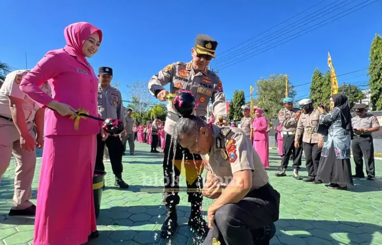 Kapolresta Banyuwangi, Kombes Pol. Dr. Rofiq Ripto Himawan, bersama Ketua Bhayangkari Cabang Banyuwangi, Ny Sari Rofiq, saat menyiram air bunga pada salah satu anggota pada momen Upacara Laporan Kenaikan Pangkat, Selasa (30/06/2026) (foto: Blok-a.com/Kuryanto).