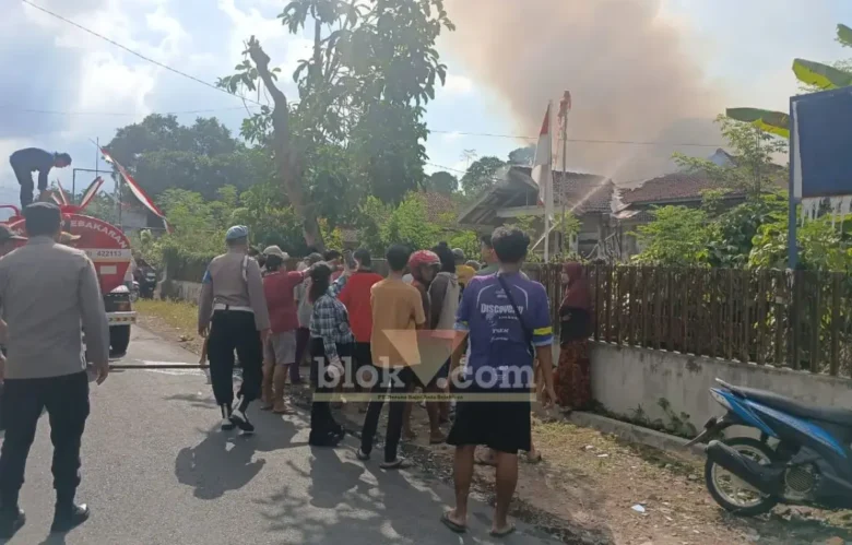 Petugas Damkar bersama polisi serta dibantu warga saat berusaha melakukan pemadaman rumah milik Sutekno, yang terbakar diduga akibat bakar sampah sembarangan, Selasa (11/08/2026) (foto: Blok-a.com/Kuryanto)