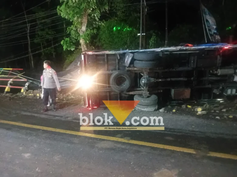 Kondisi truk Mitsubishi ber-Nopol P 8654 VS bermuatan telur, saat masih terguling usai alami laka tunggal tabrak pembatas jalan Jembatan Sapi, Glenmore, sebelum di evakuasi, Senin (26/10/2026)(blok-a.com/Kuryanto).